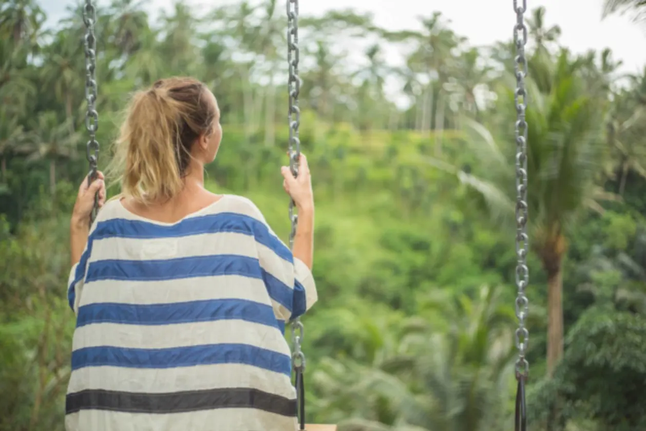 rear view of woman swinging in bali solo wellness retreat